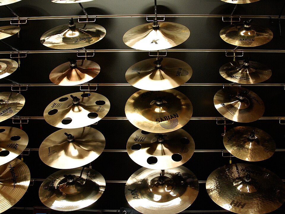 Many cymbals displayed along a store wall